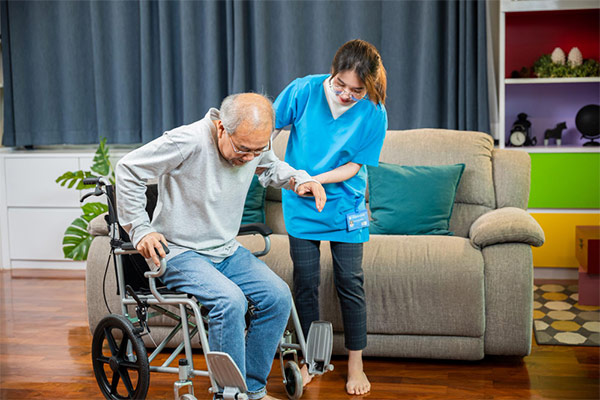 A woman assisting an elderly man in a wheelchair.